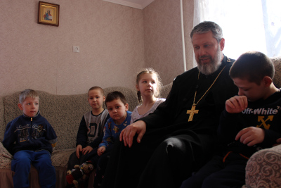 Священник Владислав Касьянов в ежедневных заботах находит время побеседовать с детьми из Луганска
